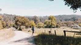 a man riding a skateboard down a dirt road
