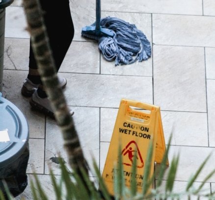 a woman sweeping the floor with a mop