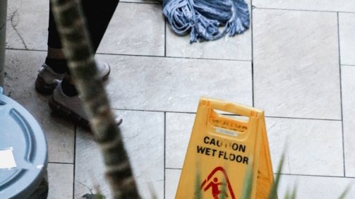 a woman sweeping the floor with a mop