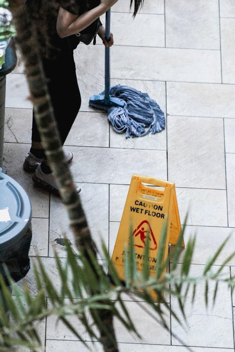 a woman sweeping the floor with a mop